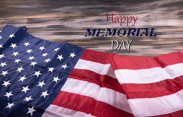 Red, white, and blue American flag   with Text MEMORIAL DAY on  wood background.