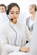 © Iryna - Call center. Group of diverse operators at work. Beautiful woman in headset communicating with customers of telemarketing service. Business concept
