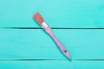 Paint brush on a blue painted wooden background