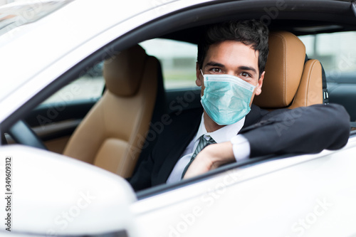 Obraz Dibond Przystojny mężczyzna jedzie jego samochód jest ubranym maskę, coronavirus pojęcie