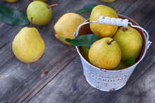 High Angle View Of Pears In Bucket On Wooden Table