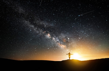 Wall Mural - beautiful starry night, girl silhouette with a camera looking at the milky way galaxy.