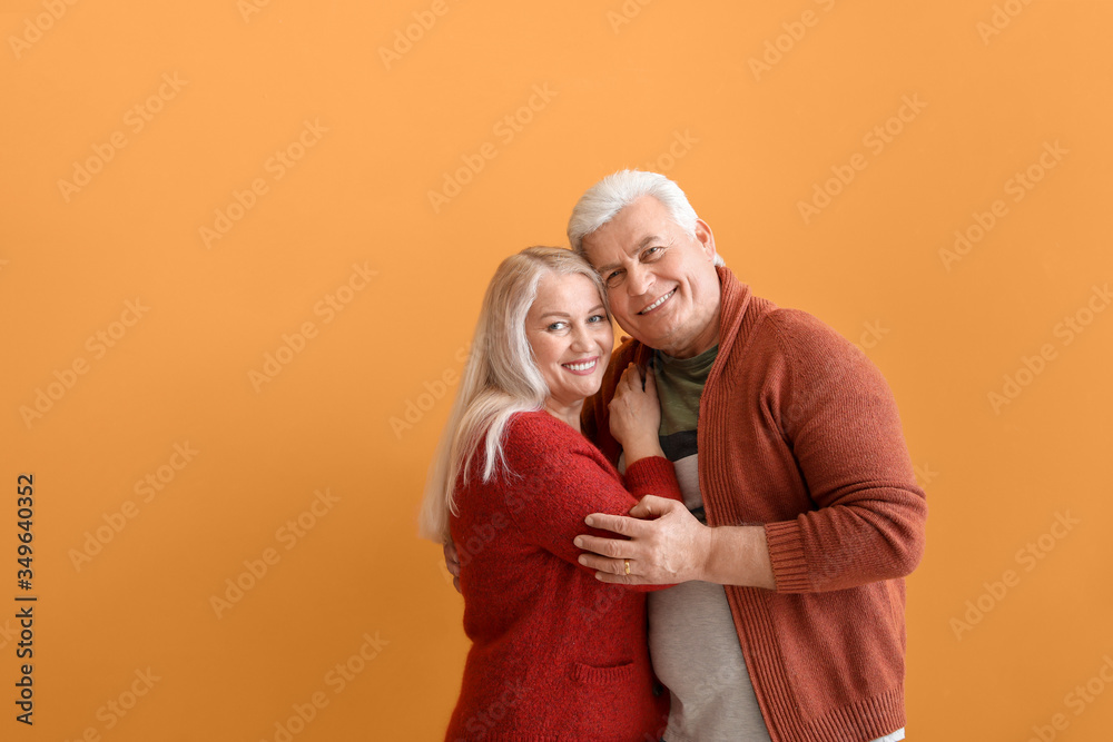 Portrait of happy elderly couple on color background