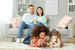 © Pixel-Shot - Happy couple with little adopted children at home