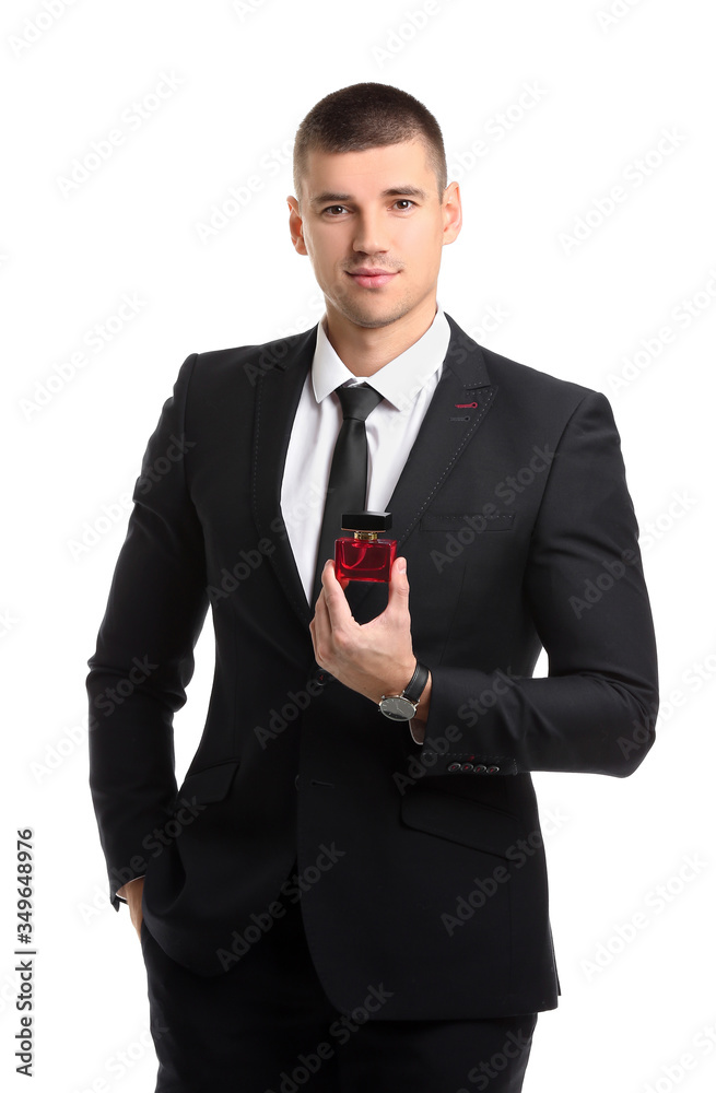 Handsome young man with bottle of perfume on white background