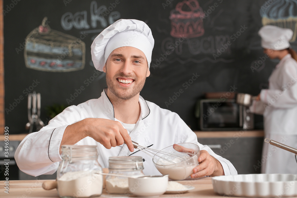 Male confectioner cooking tasty dessert in kitchen