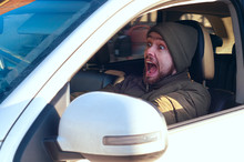 Young Man Driving A Car Shocked About To Have Traffic Accident, View From A Side Window