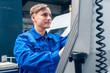 © Kzenon - Young worker programming lathe machine in factory
