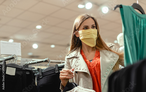 Fotomural Woman shopping in fashion store wearing face mask