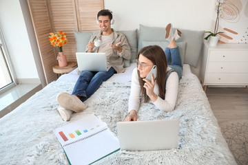 Poster - Young couple working together at home