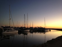 Sailboats Moored At Harbor Against Sky During Sunset