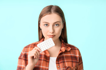 Sticker - Young woman with birth control pills on color background