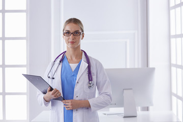 Wall Mural - Portrait of a happy smiling young doctor in headset in office