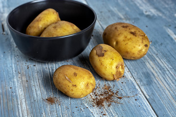 Wall Mural - heap of potatoes on light blue wooden table - closeup