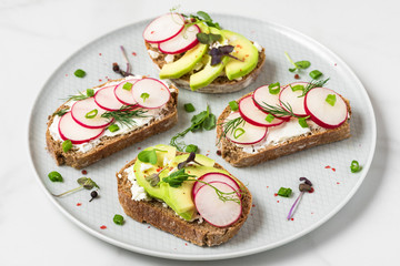 Wall Mural - Avocado and radish toast with feta cheese, sprouts and pepper in a plate for healthy breakfast