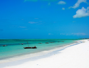 Fishing boats and crystal clear turquoise waters at paje beach village on the island of zanzibar.