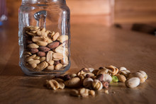 Close-up Of Nuts With Jar On Wooden Table
