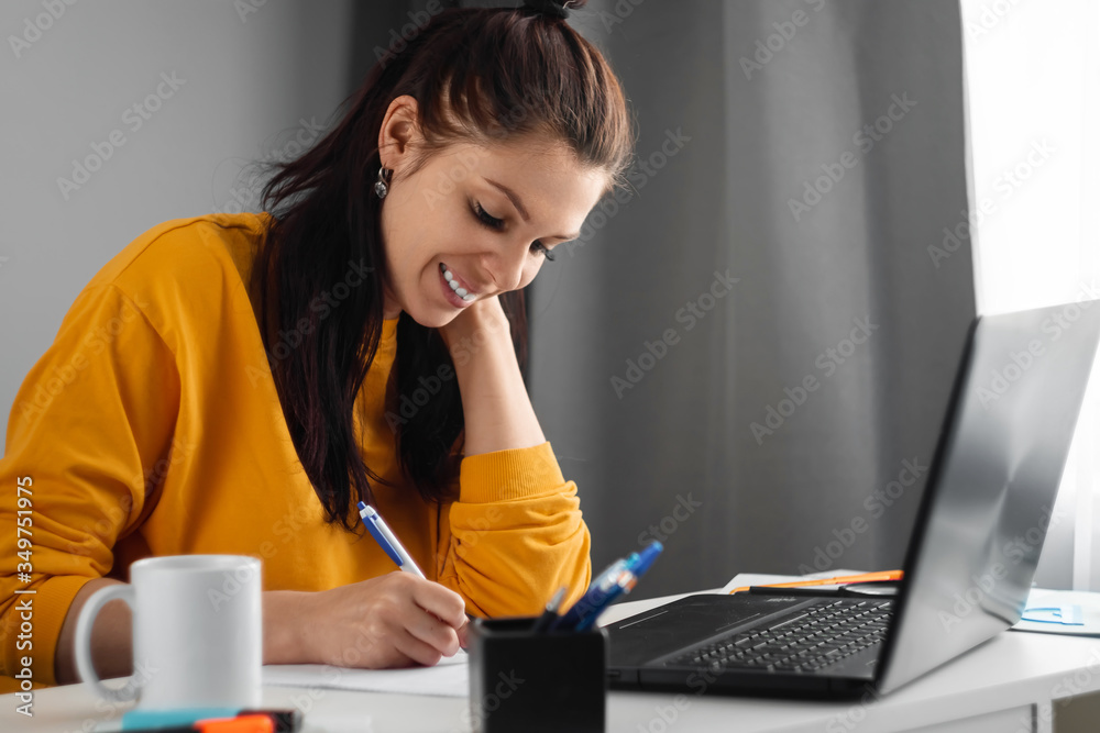 Beautiful girl using laptop studying at home, online education concept, studying science behind a laptop. Watching a webinar, looking for friends on social networks. Modern technologies. - obrazy, fototapety, plakaty 