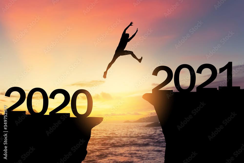 Silhouette man jumping between cliff with number 2020 to 2021 at tropical sunset beach. Freedom challenge and travel adventure holiday concept. - obrazy, fototapety, plakaty 