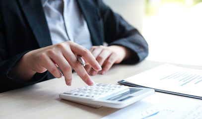 Accounting businessmen are calculating income-expenditure and analyzing real estate investment data, Dedicated to the progress and growth of the company, Financial and tax systems concept.