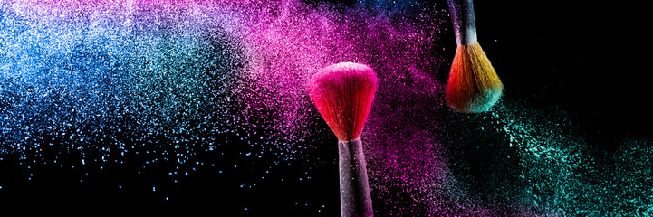 two brushes with pink and blue make up powder impact to make a colorful cloud.