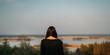 © Александра Вишнева - A young girl stands with her dark hair back and contemplates the boundless horizons and the river behind the hill at sunset.
