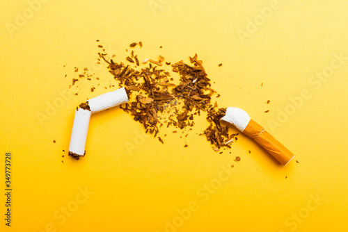 31 May of World No Tobacco Day, no smoking, close up of broken pile cigarette or tobacco STOP symbolic on yellow background with copy space, and Warning lung health concept