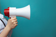 © burdun - Doctor's advice and healthcare announcement concept with white lab coat holding a megaphone isolated on blue background with space for text.
