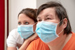 Mentally disabled woman and nurse or caretaker wearing a surgical mask, covid-19 or corona