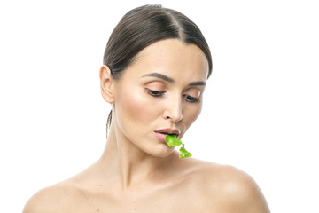 Wall Mural - portrait of a girl with clean skin without makeup with a leaf of green salad