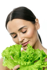 Wall Mural - portrait of a girl with clean skin without makeup with a leaf of green salad