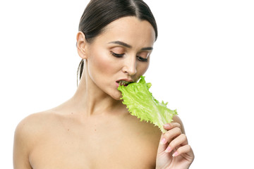 Wall Mural - portrait of a girl with clean skin without makeup with a leaf of green salad