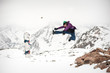 © guruXOX - Happy and positive snowboarder jump in the air on the top of beautiful Alps mountain range. Winter mountain scenic background. Panoramic view