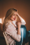 Home portrait of a beautiful young blonde woman in a white shirt and red bra.  Grain effect. Stock Photo