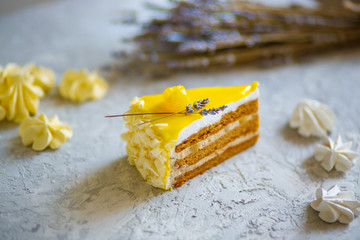 A piece of delicious cream cake. Tasty dessert. Over light wooden background.