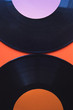 Two black vinyls arranged on a red background, top view