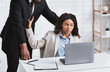 African American boss sexually harassing his female subordinate at office