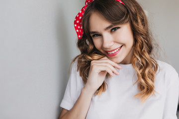 Wall Mural - Close-up shot of inspired european young lady posing with smile. Winsome emotional girl with wavy hairstyle laughing to camera.