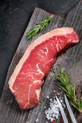 Wall Mural - Raw Brazilian steak beef picanha on a wooden Board with salt and rosemary, top view