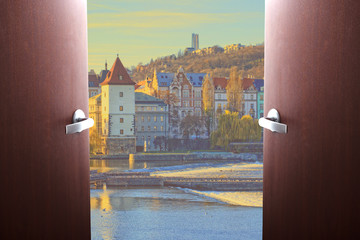 Wall Mural - End of quarantine covid-19. The beginning of travel, the opening of borders. Doors swing open overlooking Prague, Czech Republic