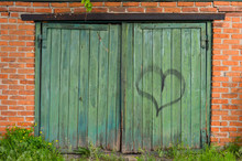 Old Green Wooden Gate With A Heart Pattern, On A Brick Wall Background