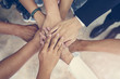 © Kris Tan - Top view of business people put hands together. Team work and unity business concept