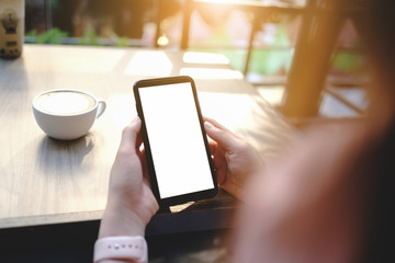 close up of woman using blank cell phone order products for shopping online within the cafe.