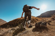 © cppzone - Hiker with backpack jums between rocks