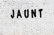 Word jaunt painted on white brick wall