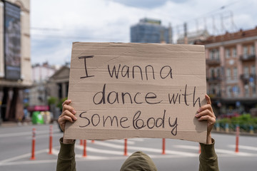 Funny inspiring text on sign. Party time motivation. Have fun. Outside protest banner message. I want to dance with somebody. Hand holding poster with call dancing and active sports. social motivation