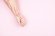 © Zireael - Beautiful women's hands with a neat delicate manicure on a pink background