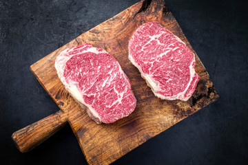 Wall Mural - Raw dry aged wagyu entrecote beef steak roast as top view on a rustic wooden cutting board