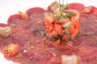 Iberian pork tenderloin carpaccio dish with tomato, garlic and olive oil.