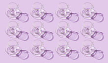 Pattern Of Empty Glass Cups With Shadow On A Lilac Background.
